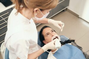 Female dentist scanning teeth of woman